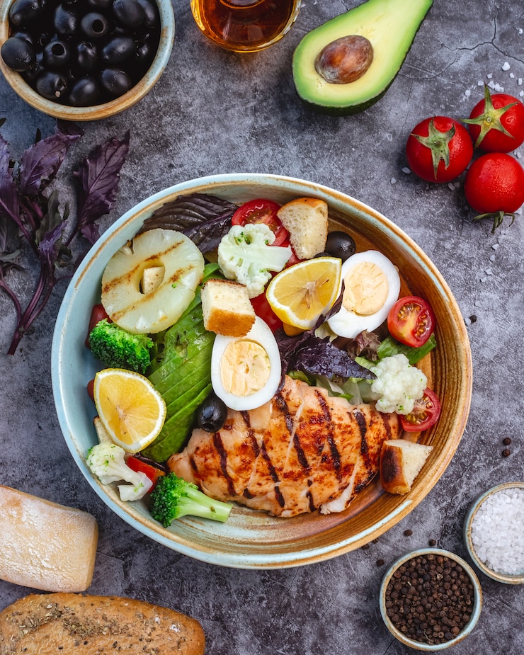 top-view-healthy-diet-salad-with-grilled-chicken-broccoli-cauliflower-tomato-lettuce-avocado-lettuce_141793-2439